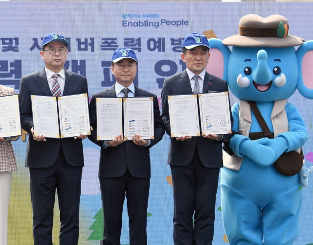 Heads of relevant organizations are posing for a photo while holding the agreement document at the youth violence prevention signing ceremony.