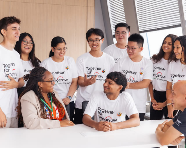 Global top 10 contestants of Samsung Solve for Tomorrow wearing digital community T-shirts are engaging in conversation at the 2024 Paris Olympics.